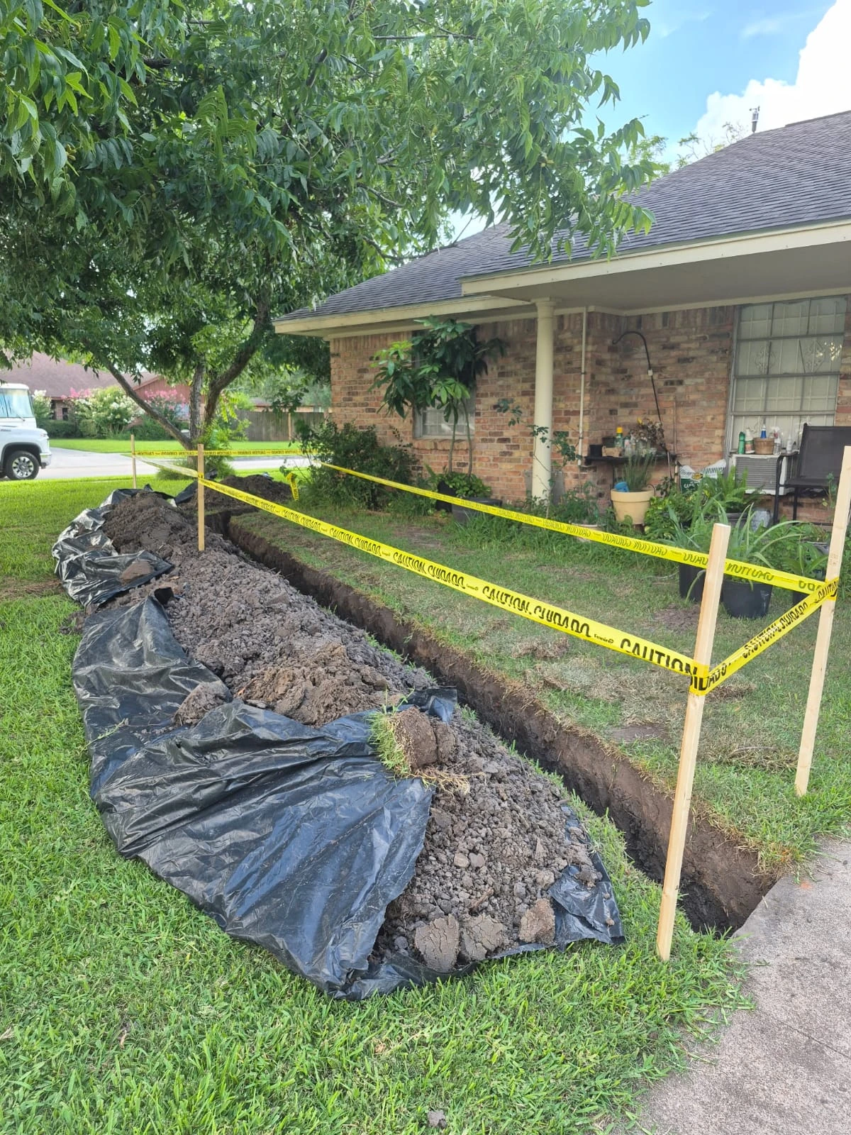 Community Q and A for Houston homeowners featuring an active residential trenching project with safety caution tape.